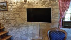 Elle comprend une télévision à écran plat suspendue à un mur en pierre. dans l'établissement Hiža Golubić, à Vinica