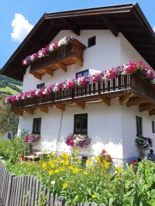 a white house with flowers on the balcony at Ferienwohnung Valentin in Grossarl