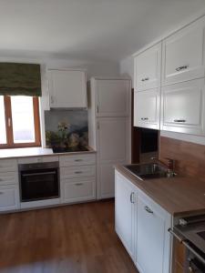 a white kitchen with white cabinets and a sink at Ferienwohnung Valentin in Grossarl
