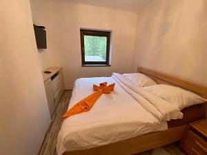 1 dormitorio con 1 cama con arco naranja en Chopok juh Apartman Vanda en Tale