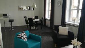 uma sala de estar com uma cadeira azul e uma mesa em Le FOURNIRUE T2 em Metz