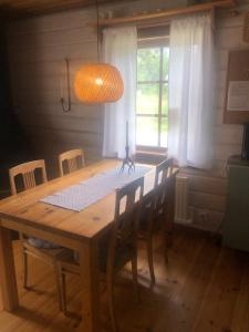 a dining room table with chairs and a light fixture at Baggården fjällby, Messlingen in Messlingen