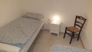 a small bedroom with a bed and a chair at Appartamento In Paese in Niscemi