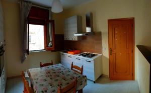 eine Küche mit einem Tisch, einem Herd, einem Tisch und einem Tisch in der Unterkunft Appartamento In Paese in Niscemi
