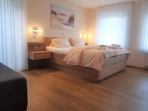 1 dormitorio con 1 cama grande y 2 ventanas en Hotel Penterknapp, en Bramsche