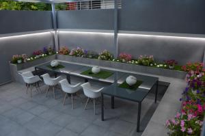 eine Terrasse mit 2 Tischen, Stühlen und Blumen in der Unterkunft S. Luxury Princess Suite in Nea Kallikratia