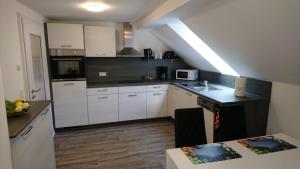 a small kitchen with white cabinets and a table at Haus Waldidyll in Lauta