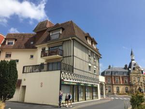 a building with people standing in front of it at Hyper Centre - 2 PIÈCES tout confort - Terrasse - ascenseur - in Cabourg