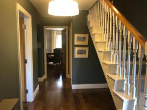 un couloir avec un escalier dans une maison aux murs verts dans l'établissement Cromwells Court, à Kenmare