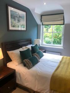a bedroom with a bed with pillows and a window at Cromwells Court in Kenmare