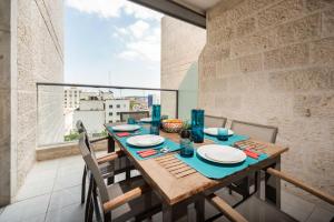 una sala da pranzo con tavolo e una grande finestra di Rav Kook Luxury Complex - 4BDR a Gerusalemme