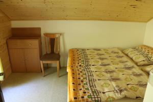 a bedroom with a bed and a table and a chair at Chata Babeta Hrádeček u Trutnova in Hertvíkovice