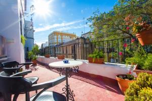 a patio with a table and chairs on a balcony at Casa del siglo XVII in Seville