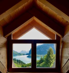 a window in a cabin with a view of a lake at Agriturismo Ai Castioni in Molveno