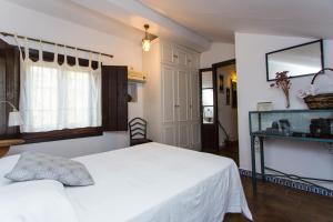 a bedroom with a white bed and a window at Casa del siglo XVII in Seville