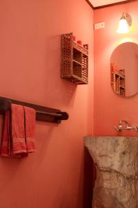 La salle de bains est pourvue de serviettes rouges, d'un miroir et d'un lavabo. dans l'établissement Casa Rural Aroma de Campo, à Curubandé