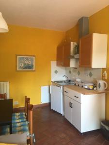 a kitchen with yellow walls and a white refrigerator at Appartamento il Giglio in Montale +6 photos