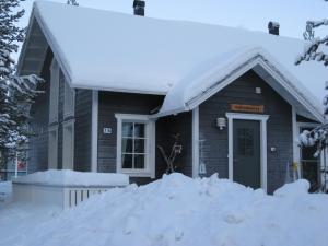 uma casa com um monte de neve em frente em Tunturikoivu em Ylläsjärvi