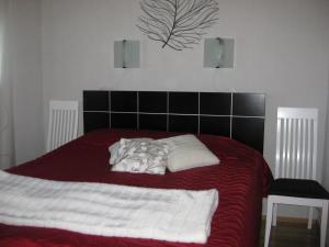 - un lit avec une couverture rouge et blanche et 2 oreillers dans l'établissement Tunturikoivu, à Ylläsjärvi