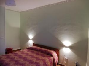 1 dormitorio con 1 cama y 2 luces en la pared en Polla B&B Day Use, en Polla