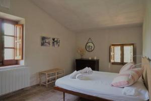 1 dormitorio con 1 cama y reloj en la pared en Masoveria del Mas Plaja de Fitor, en Palafrugell