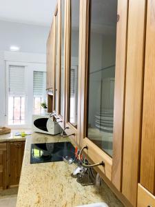 a kitchen with a sink and wooden cabinets at Apartamento Las Gacelas in Mazagón