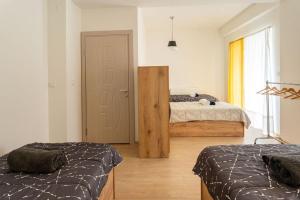 a bedroom with two beds and a door with a window at Hostel Denica in Skopje
