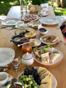 ,,Anna's" Guesthouse في Nizhniy Alvani: طاولة خشبية عليها صحون طعام