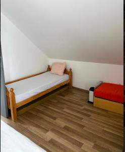 een kleine slaapkamer met een bed en een rode matras bij Pipacs in Balatonszárszó