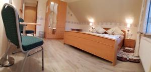 1 dormitorio pequeño con 1 cama y 1 silla en Gasthof & Pension Erlengrund en Gersfeld