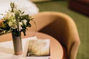 克里格拉赫的住宿－Gasthof Rothwangl Hannes，花瓶,花瓶上满是白色的花朵,坐在桌子上