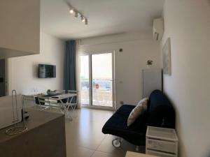 un soggiorno con divano e tavolo di Vista Mare Apartment con parcheggio privato a Marina di Ragusa
