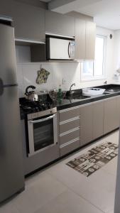 a kitchen with a stainless steel stove top oven at Apartamento em Torres in Torres
