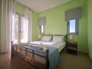 1 dormitorio con 1 cama con paredes y ventanas verdes en Xi House, en Xi