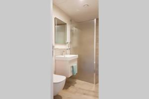 Un baño con inodoro, lavabo y ducha. en Suite with back garden, en Karlovy Vary