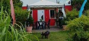 ein rotes Haus mit einem Tisch und Stühlen im Hof in der Unterkunft Garden-Loft in Stadelhofen