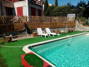 a swimming pool with two chairs and a table at palayson two in Le Muy +12 photos