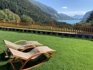 a couple of chairs sitting in the grass at Agriturismo Ai Castioni in Molveno