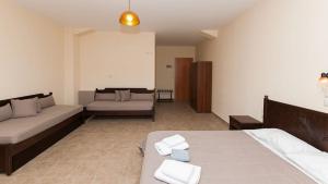 a large room with a bed and a couch at Anopoli Rooms in Sinoikismós Kámbos +6 photos