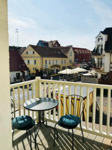 a balcony with two chairs and a table and a table at Ahoj Apartments in Ustka