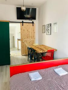 ウストカにあるAhoj Apartmentsのダイニングルーム(テーブル、赤いソファ付)