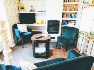 a living room with blue chairs and a table and a tv at LA CLOSERIE in Bouillon