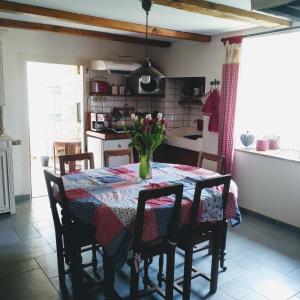 eine Küche mit einem Tisch und einer Blumenvase darauf in der Unterkunft LA CLOSERIE in Bouillon