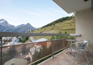 a balcony with a chair and a view of a mountain at Appartement 4 personnes (+1) LES 2 ALPES in Mont-de-Lans