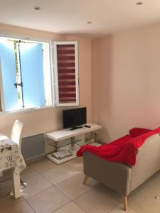 ein Wohnzimmer mit einem Sofa und einem Schreibtisch mit einem Computer in der Unterkunft Maisonnette El Puy in Moltig les Bains