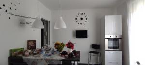 a kitchen with a table and a clock on the wall at LA TERRAZZA in Falconara Marittima