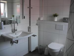 a white bathroom with a sink and a toilet at Ferienwohnung Meyer in Bleckede