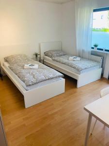 Duas camas num quarto com pisos em madeira em Pension Platzhirsch em Mücke