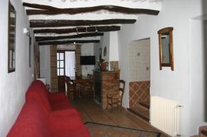 sala de estar con sofá rojo y mesa en Apartamentos y Casas Rurales Las Terrazas de la Alpujarra, en Bubión