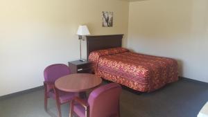 a hotel room with a bed and a table and chairs at Safari Inn Motel in Winston